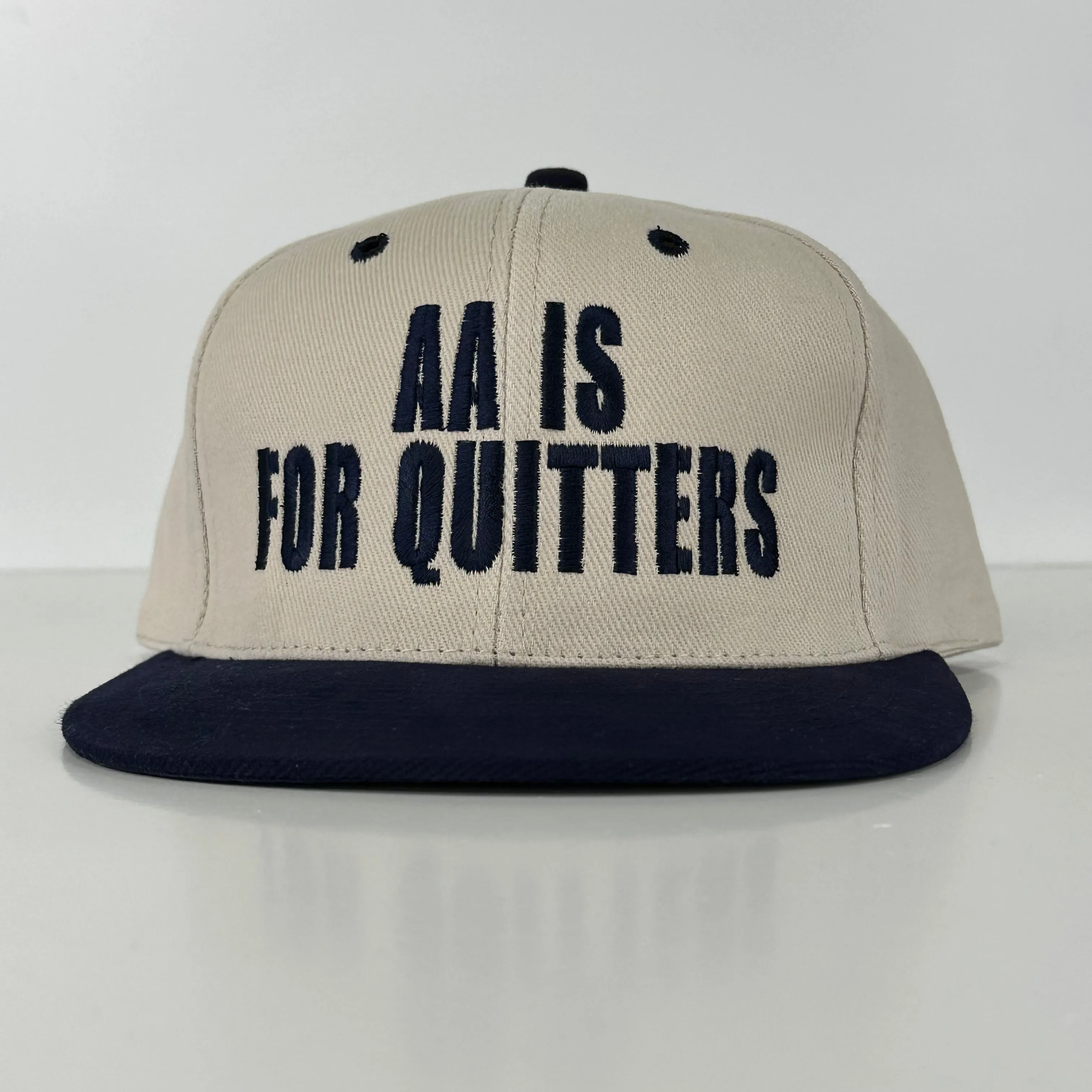 AA is for quitters in navy thread on khaki and navy Strapback hat custom embroidery