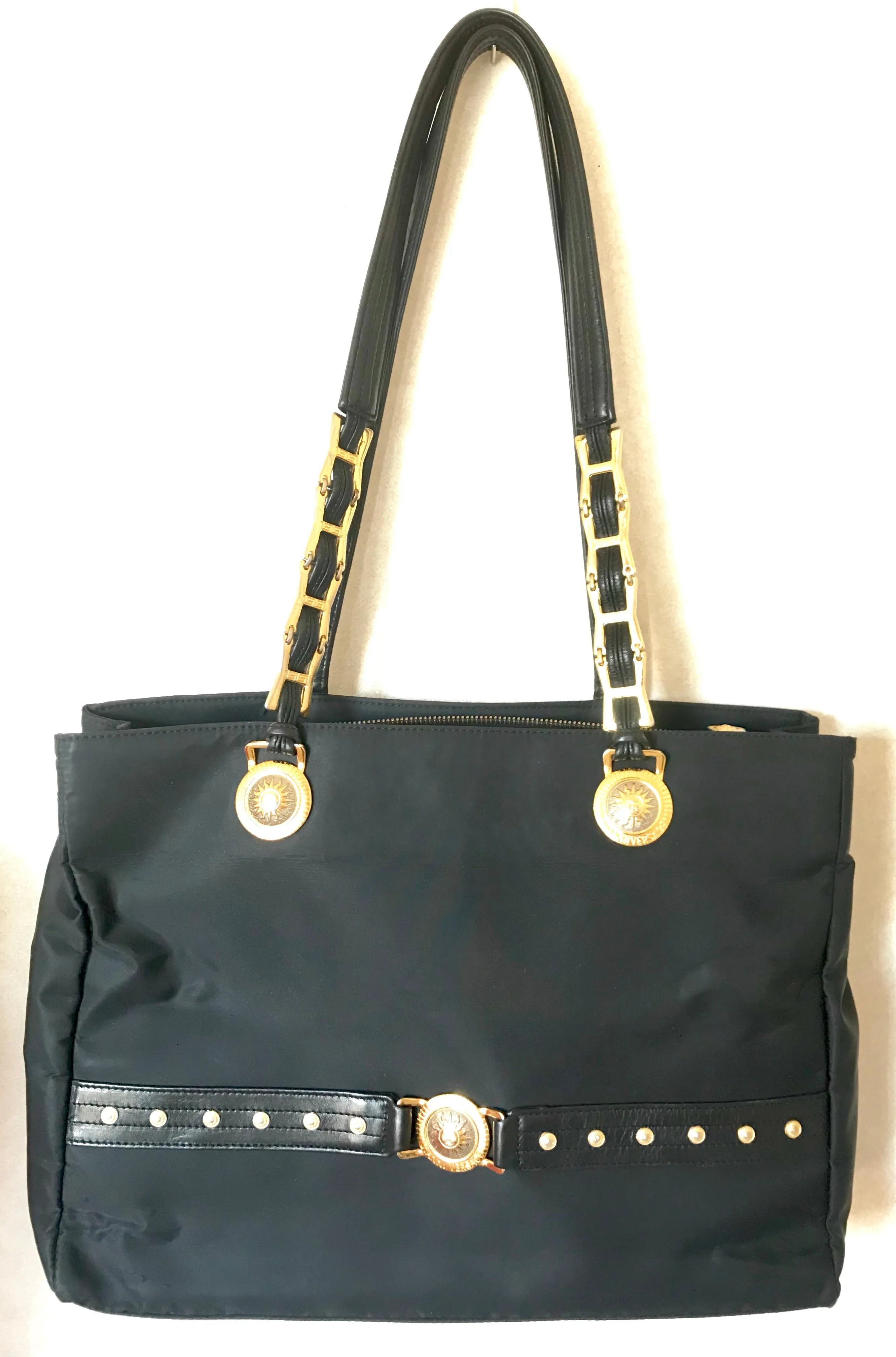Vintage Gianni Versace large black nylon and leather combination tote bag with gold tone sunburst motifs and chains. 050425r4