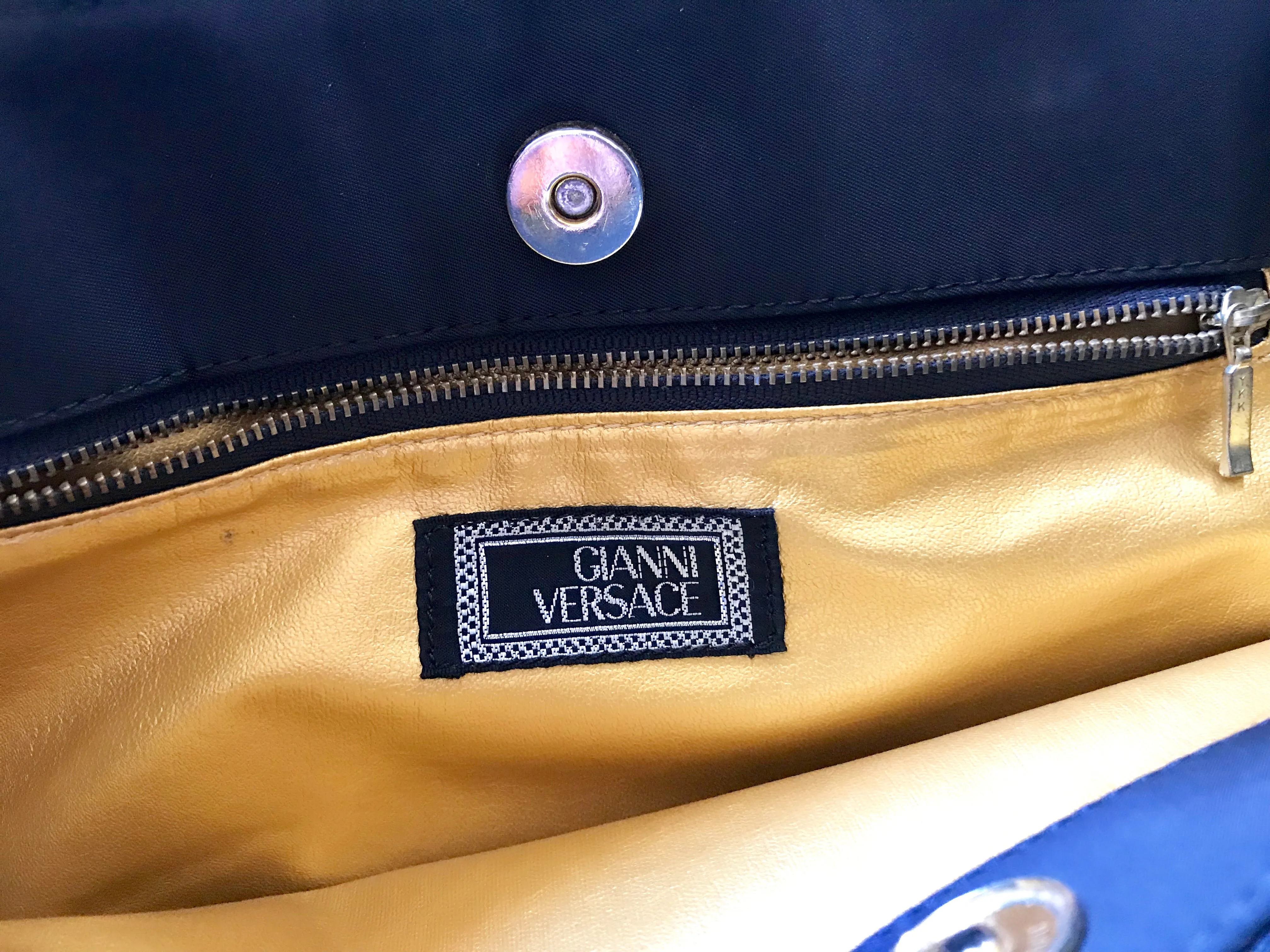 Vintage Gianni Versace large black nylon and leather combination tote bag with gold tone sunburst motifs and chains. 050425r4