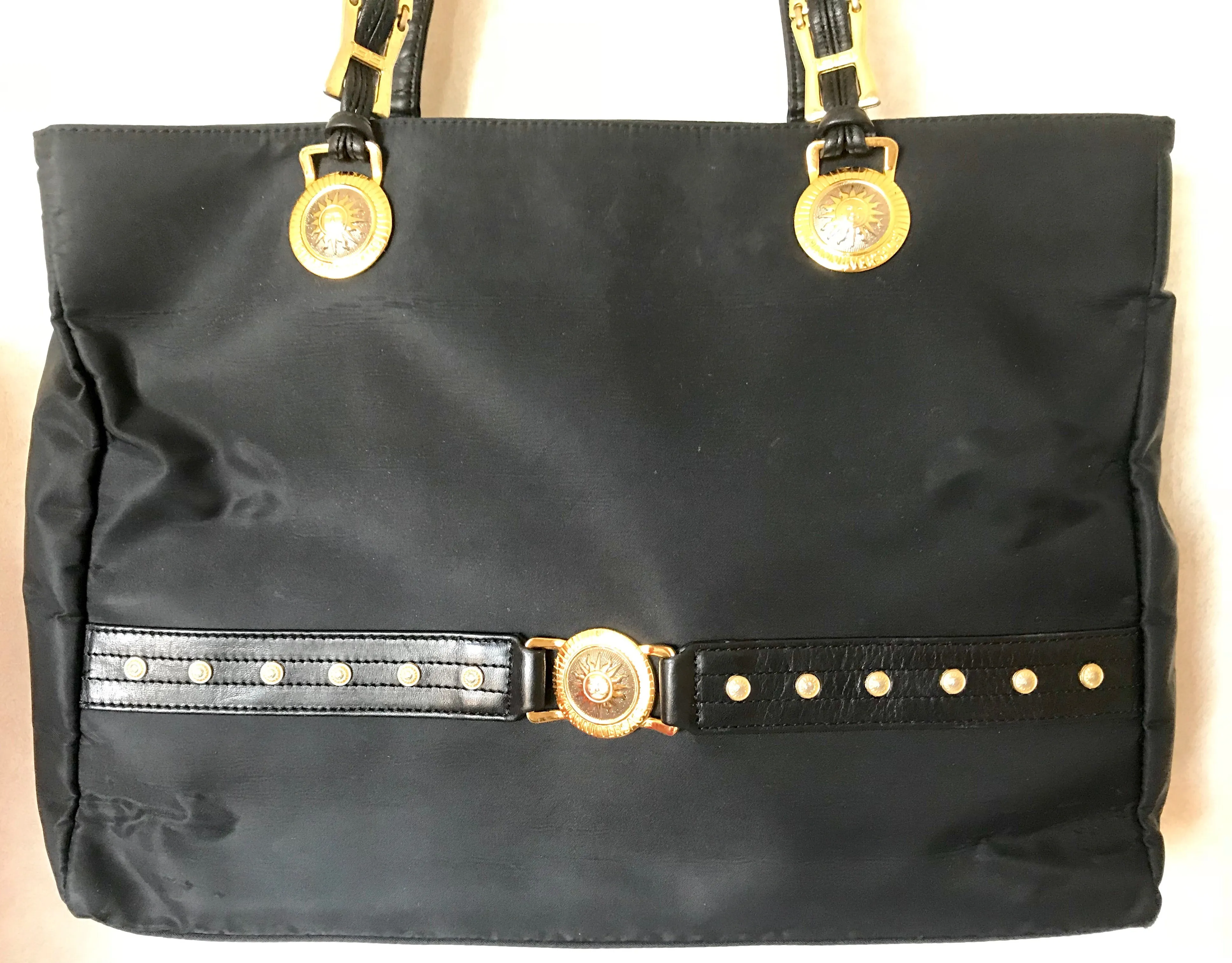 Vintage Gianni Versace large black nylon and leather combination tote bag with gold tone sunburst motifs and chains. 050425r4