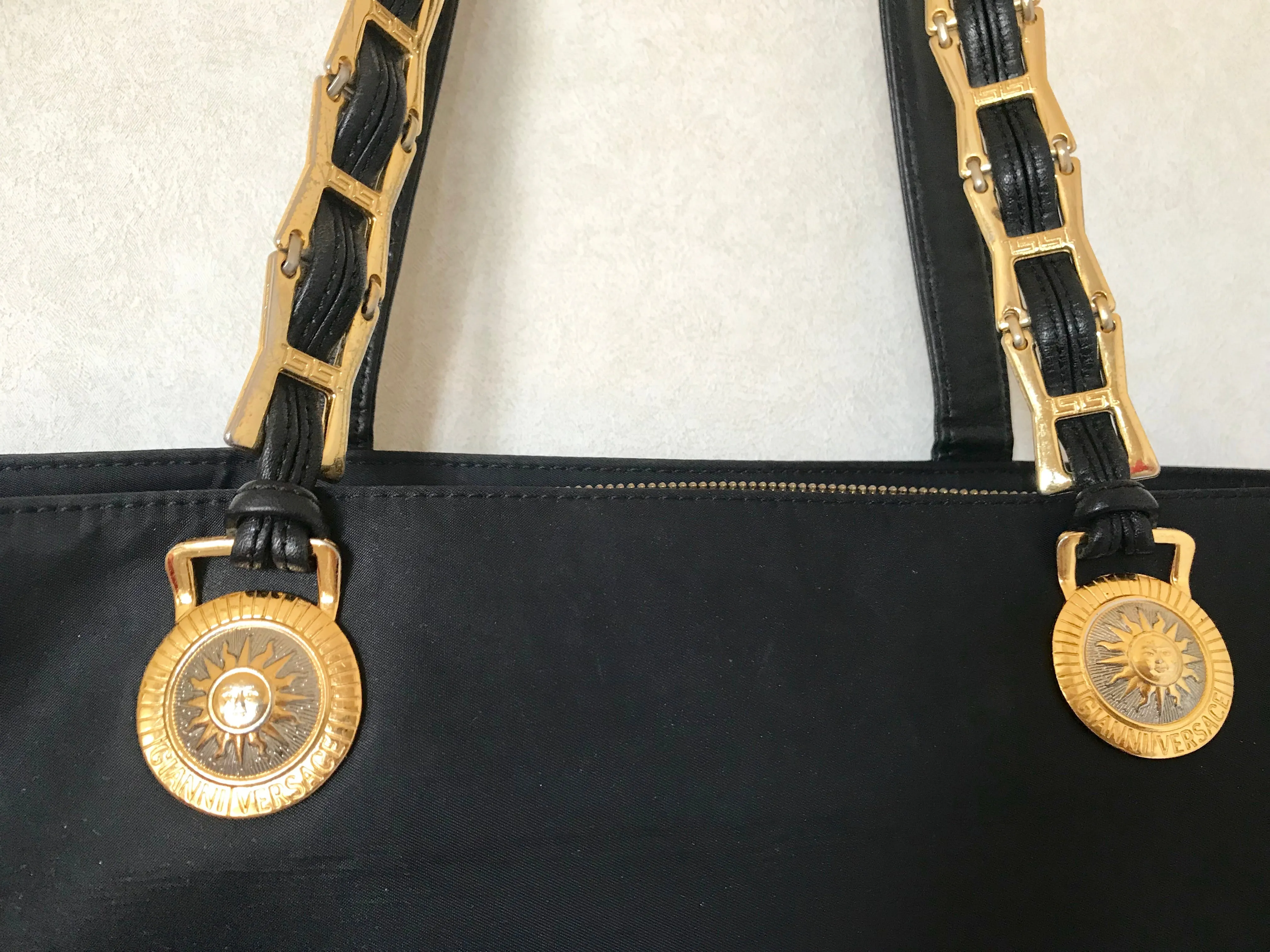Vintage Gianni Versace large black nylon and leather combination tote bag with gold tone sunburst motifs and chains. 050425r4
